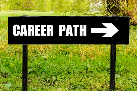 Black sign with "Career Path" and a white arrow pointing right, placed outdoors on a grassy area.