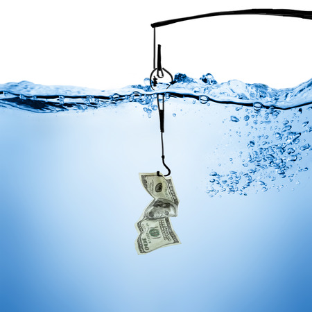 A fishhook holding a folded U.S. dollar bill is submerged in clear blue water with bubbles.