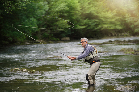 man in the creek fly fishing