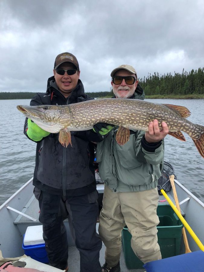 two men holding northern pike fish they caught at Lawrence Bay Lodge