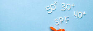 Sunscreen bottle with "SPF 20+, 30+, 40+, 50+" written in lotion on a blue background.