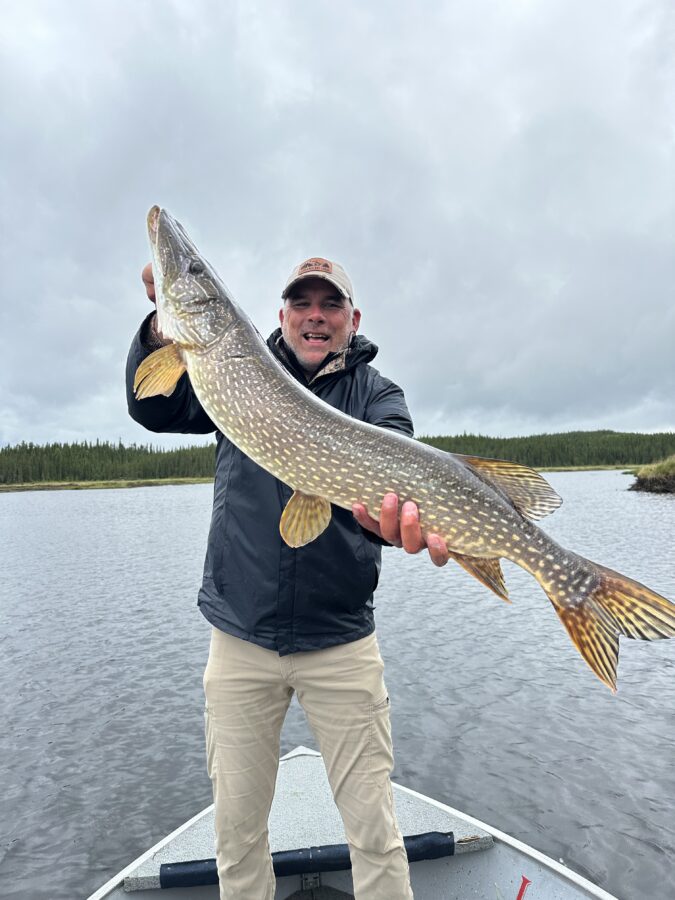 man getting his picture taken holding his trophy catch